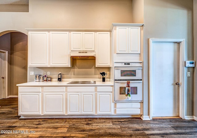 kitchen with dark wood-style floors, double oven, black electric cooktop, and under cabinet range hood