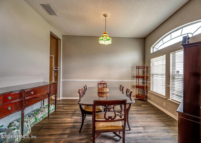 dining area with visible vents, a textured ceiling, baseboards, and wood finished floors