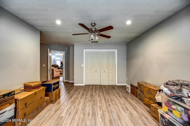 interior space with visible vents, baseboards, ceiling fan, a textured ceiling, and light wood-style floors