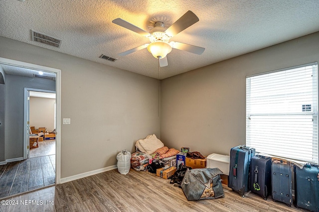 interior space featuring visible vents, a textured ceiling, and wood finished floors