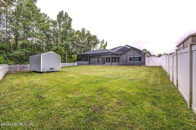 view of yard featuring an outbuilding, glass enclosure, a fenced backyard, and a storage unit