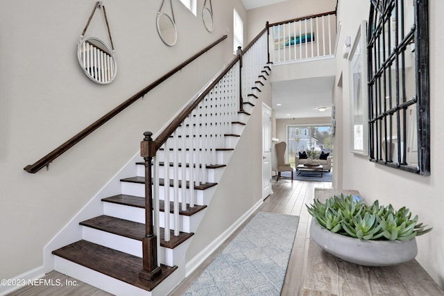 foyer with a towering ceiling and hardwood / wood-style floors