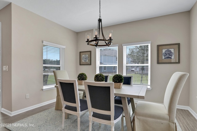 dining area with wood-type flooring and a notable chandelier