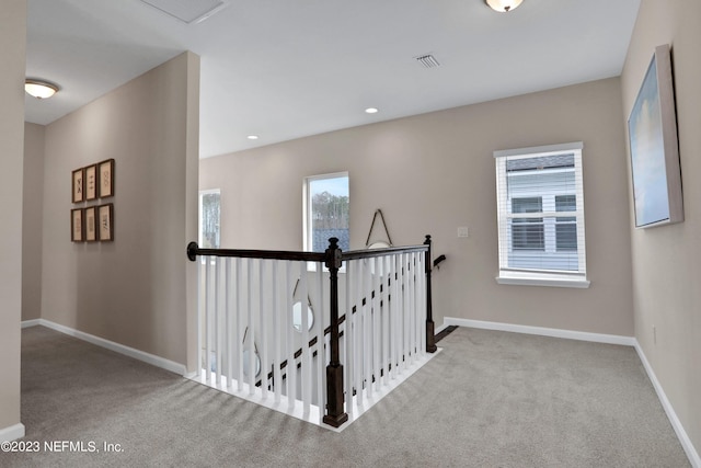 hall featuring light colored carpet