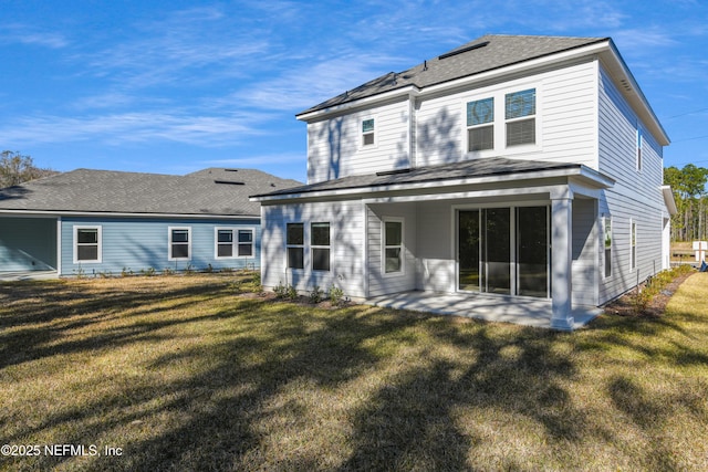 back of house with a patio area and a lawn