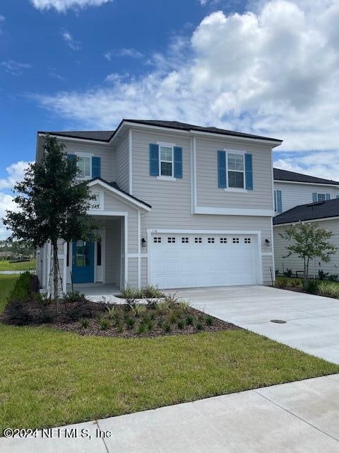 view of front of house with a garage and a front lawn