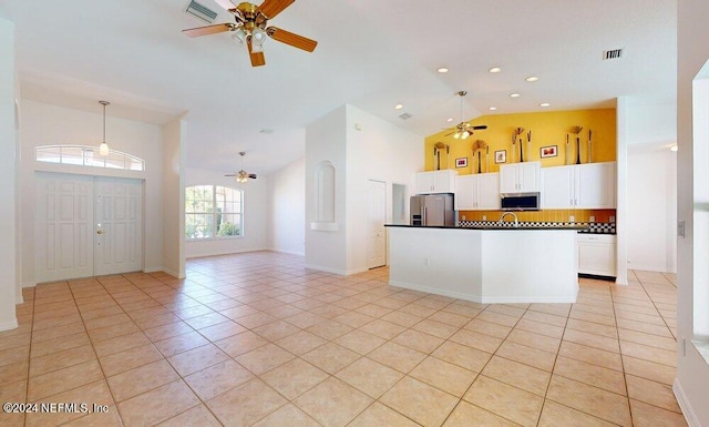 kitchen with stainless steel appliances, light tile patterned floors, decorative backsplash, white cabinetry, and ceiling fan