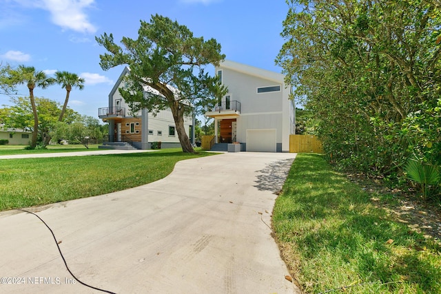 view of front of home featuring a balcony, a front lawn, and a garage