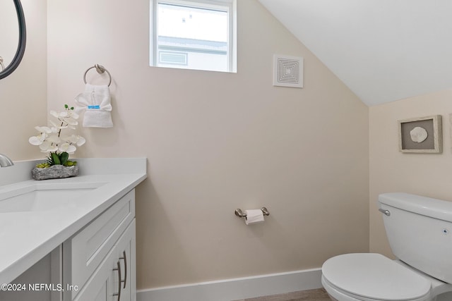 bathroom featuring lofted ceiling, vanity, and toilet