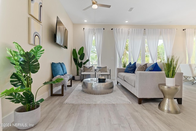 living room featuring ceiling fan and light hardwood / wood-style floors