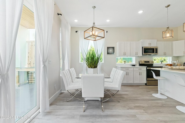 dining space featuring light hardwood / wood-style floors and a chandelier