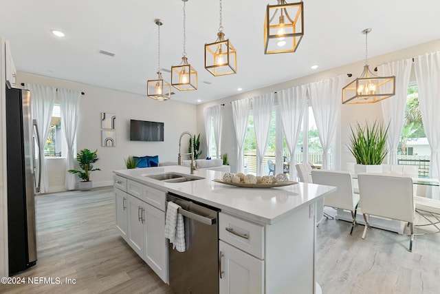 kitchen with sink, white cabinetry, hanging light fixtures, and appliances with stainless steel finishes