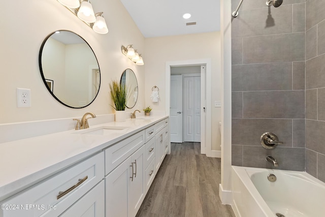 bathroom with vanity, tiled shower / bath combo, and hardwood / wood-style flooring