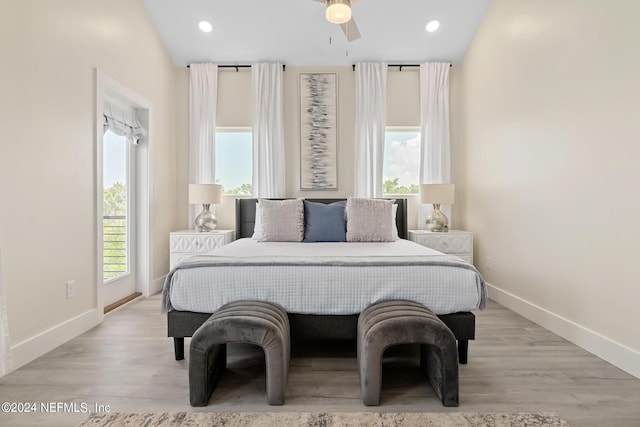 bedroom featuring lofted ceiling, multiple windows, ceiling fan, and light hardwood / wood-style floors