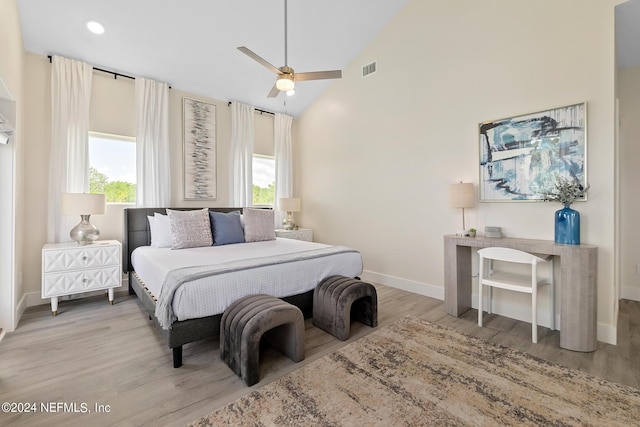 bedroom featuring ceiling fan, high vaulted ceiling, light hardwood / wood-style flooring, and multiple windows