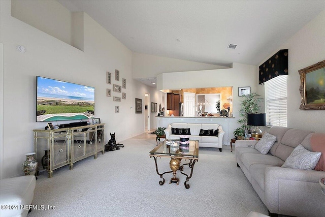 carpeted living room with high vaulted ceiling