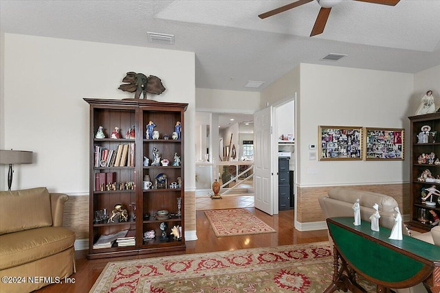 living room featuring a textured ceiling, hardwood / wood-style flooring, and ceiling fan