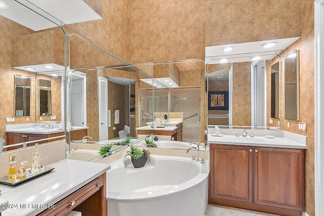 bathroom featuring a washtub, a high ceiling, vanity, and tile patterned flooring