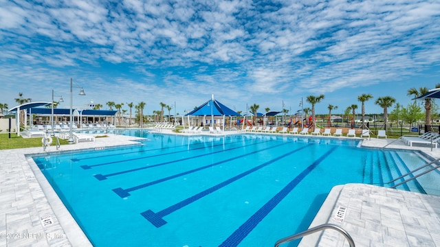 community pool featuring fence and a patio