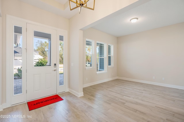 foyer with a chandelier, light hardwood / wood-style flooring, and a wealth of natural light