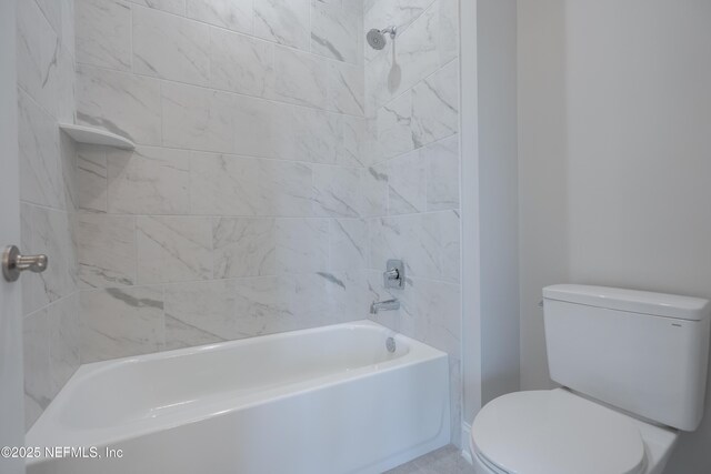 bathroom with toilet and tiled shower / bath