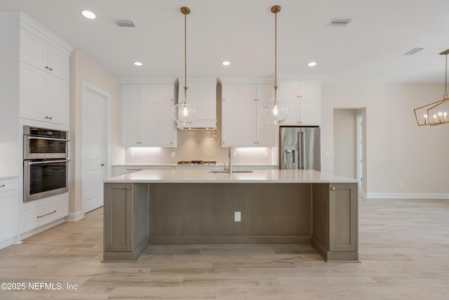 kitchen with appliances with stainless steel finishes, a sink, and white cabinetry