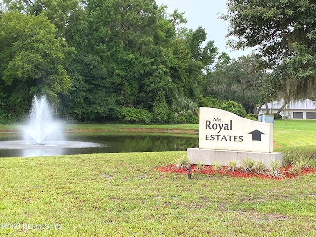 view of home's community featuring a lawn and a water view