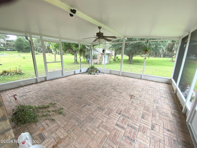 unfurnished sunroom featuring ceiling fan