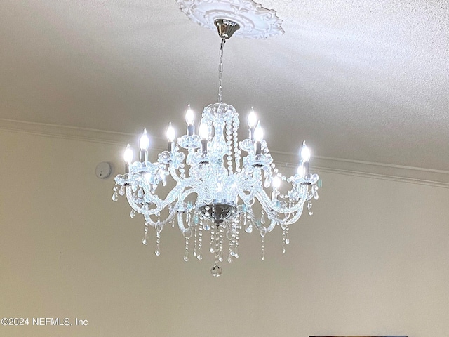 details with crown molding, a chandelier, and a textured ceiling