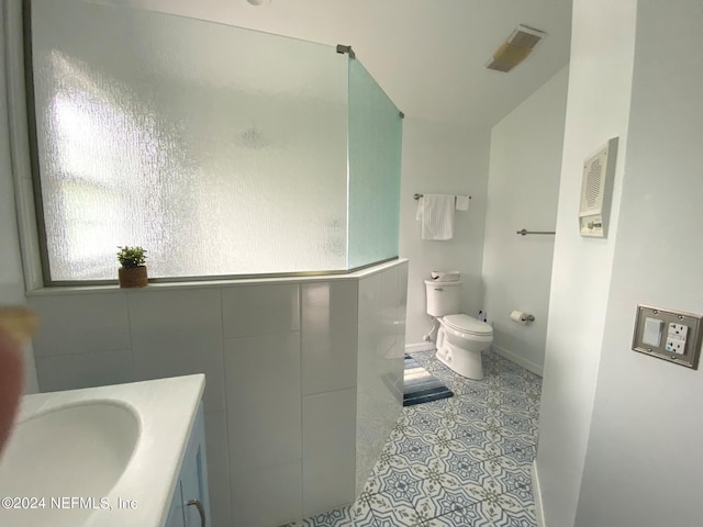 bathroom featuring toilet, visible vents, baseboards, vanity, and tile patterned floors