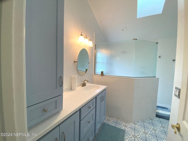 bathroom with vanity, a skylight, and tile patterned floors