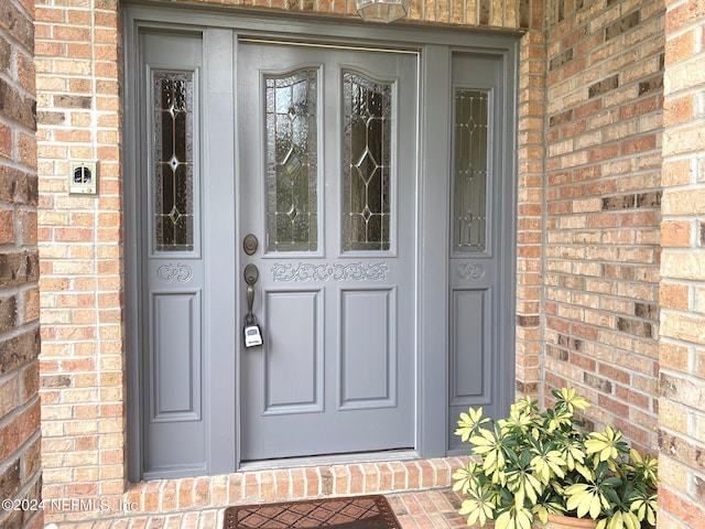 view of exterior entry with brick siding