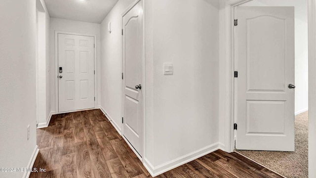 corridor with dark hardwood / wood-style flooring