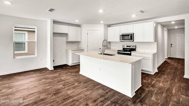 kitchen with sink, dark hardwood / wood-style floors, a center island with sink, white cabinets, and appliances with stainless steel finishes