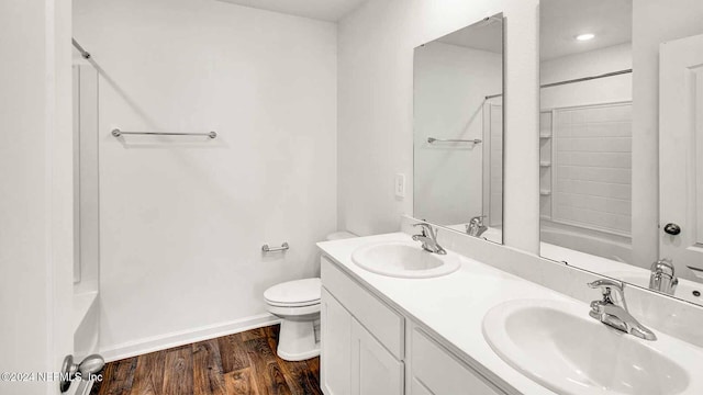 full bathroom with shower / bathing tub combination, hardwood / wood-style floors, vanity, and toilet