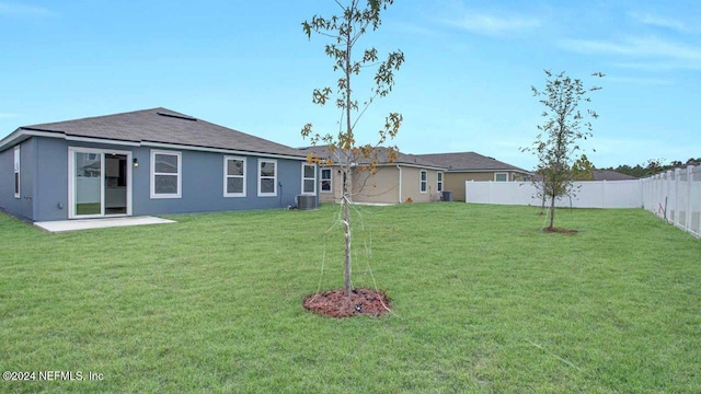 back of house with a patio area, a yard, and central AC