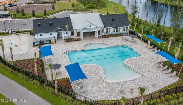 view of pool featuring a patio area and a water view