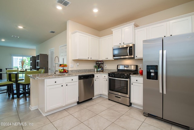 kitchen featuring white cabinetry, stainless steel appliances, kitchen peninsula, and sink