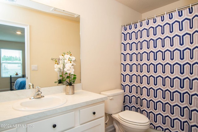 bathroom with vanity, walk in shower, and toilet