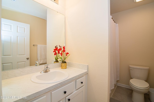 bathroom featuring vanity, tile patterned floors, and toilet