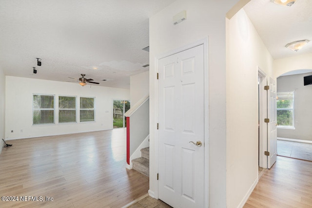 hallway featuring a textured ceiling and light hardwood / wood-style flooring