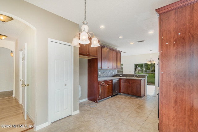 kitchen featuring sink, decorative light fixtures, backsplash, dishwasher, and a notable chandelier