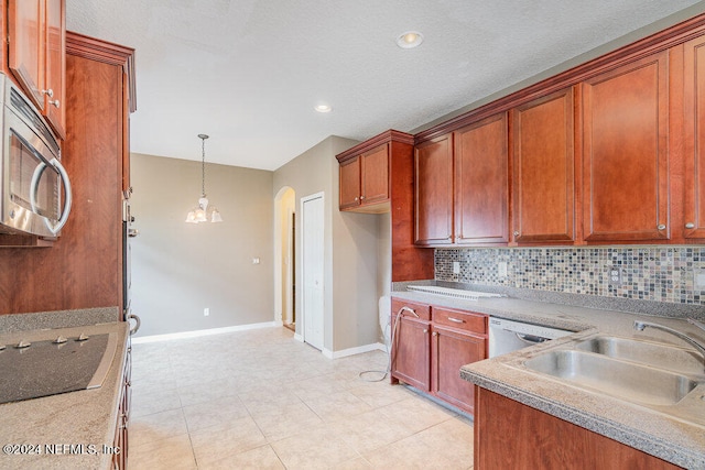 kitchen with tasteful backsplash, sink, hanging light fixtures, appliances with stainless steel finishes, and light tile patterned floors