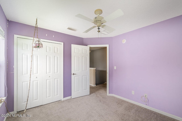 unfurnished bedroom featuring light carpet, a closet, and ceiling fan