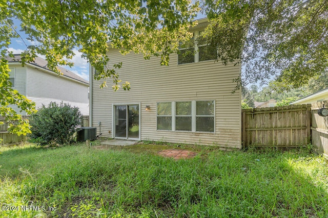 rear view of house with a lawn and central air condition unit