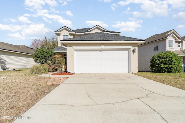 traditional home featuring concrete driveway, an attached garage, and stucco siding