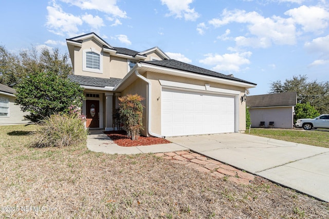 traditional-style home featuring driveway, a garage, roof with shingles, a front lawn, and stucco siding