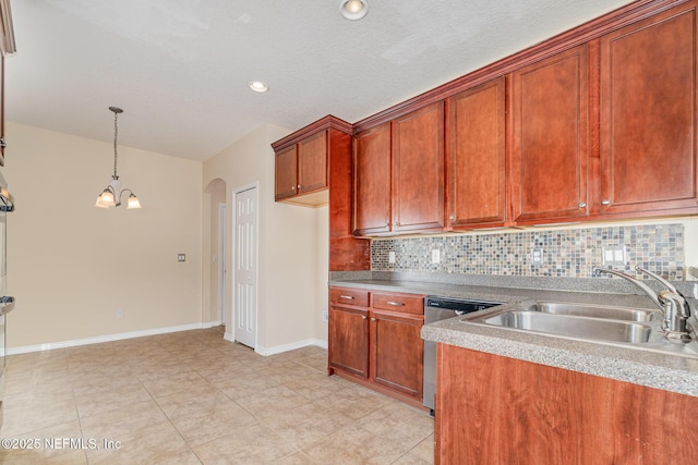 kitchen with arched walkways, pendant lighting, tasteful backsplash, stainless steel dishwasher, and a sink