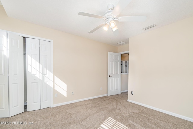 unfurnished bedroom with carpet floors, a ceiling fan, visible vents, baseboards, and a closet