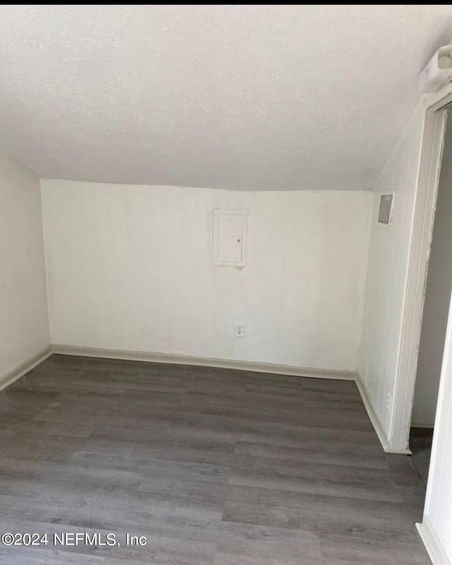 bonus room with lofted ceiling, a textured ceiling, baseboards, and dark wood-type flooring